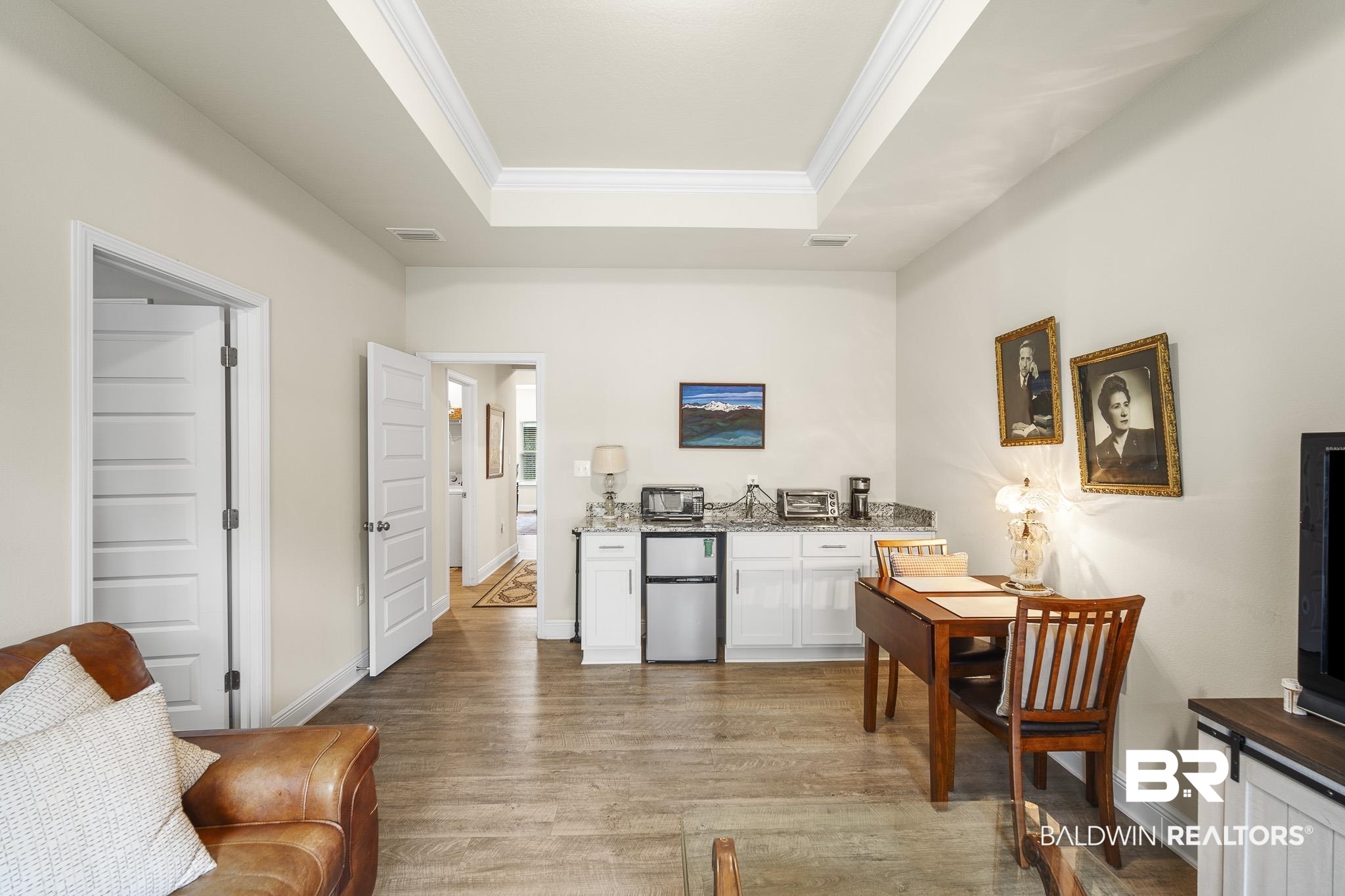 24765 Spectacular Bid Loop Daphne, AL 36526 - Photo 17 of 45 Kitchen featuring stainless steel refrigerator, hardwood / wood-style floors, ornamental molding, white cabinets, and a raised ceiling