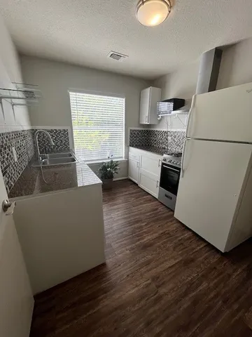 a living room with furniture and a refrigerator