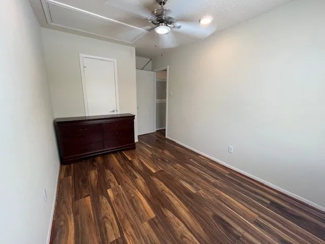 a view of a room with wooden floor and a ceiling fan