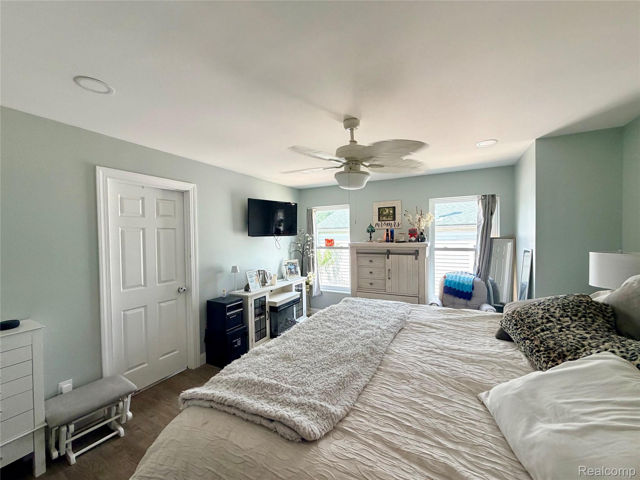 3840 East Dunbar Road Monroe, MI 48161 - Photo 24 of 38 Spacious room featuring wood-finish flooring, two large windows with horizontal blinds, a white ceiling fan with integrated lighting, and recessed ceiling lights