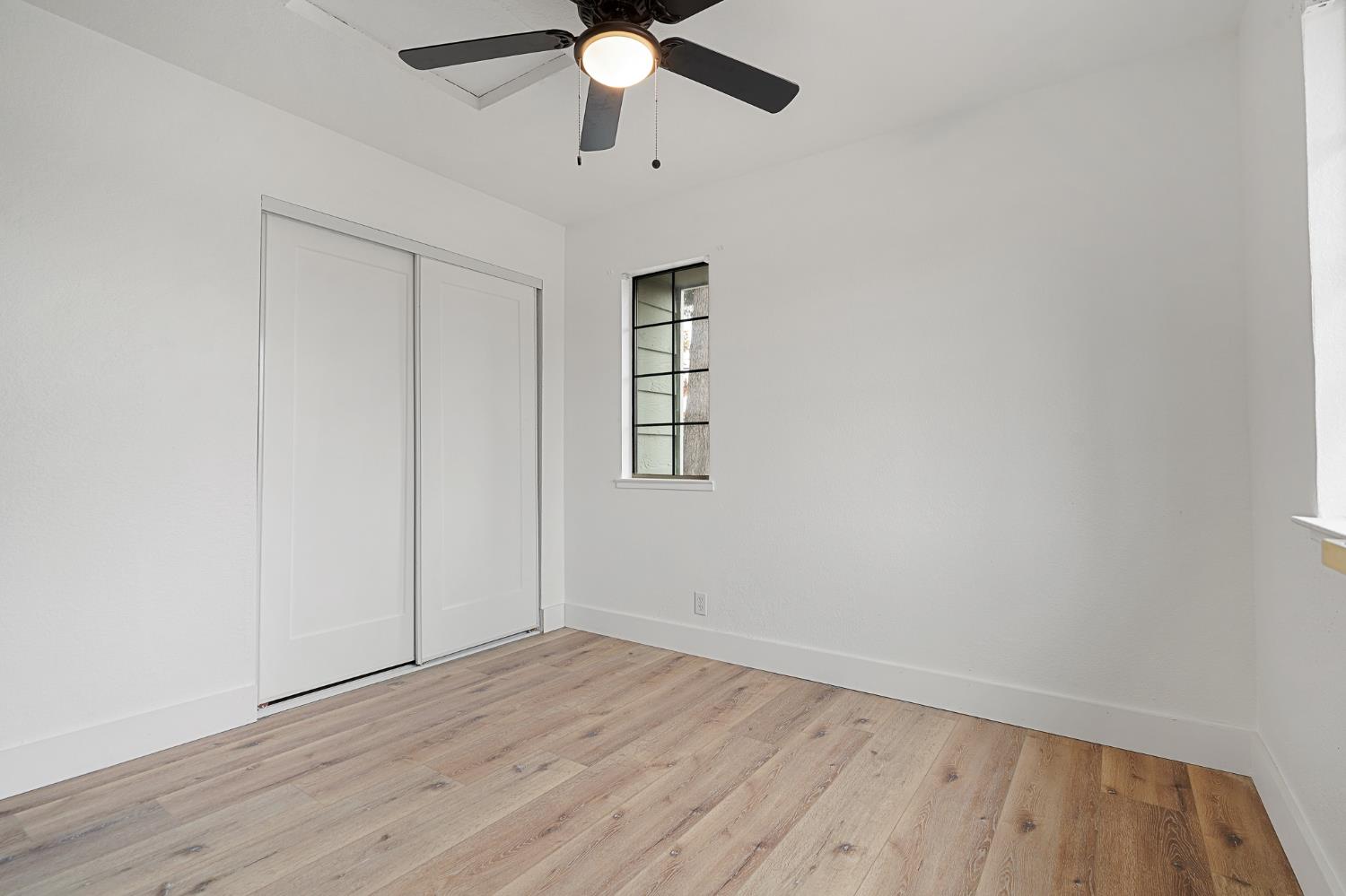 335 West Clover Road Tracy, CA 95376 - Photo 33 of 49 an empty room with wooden floor ceiling fan and windows