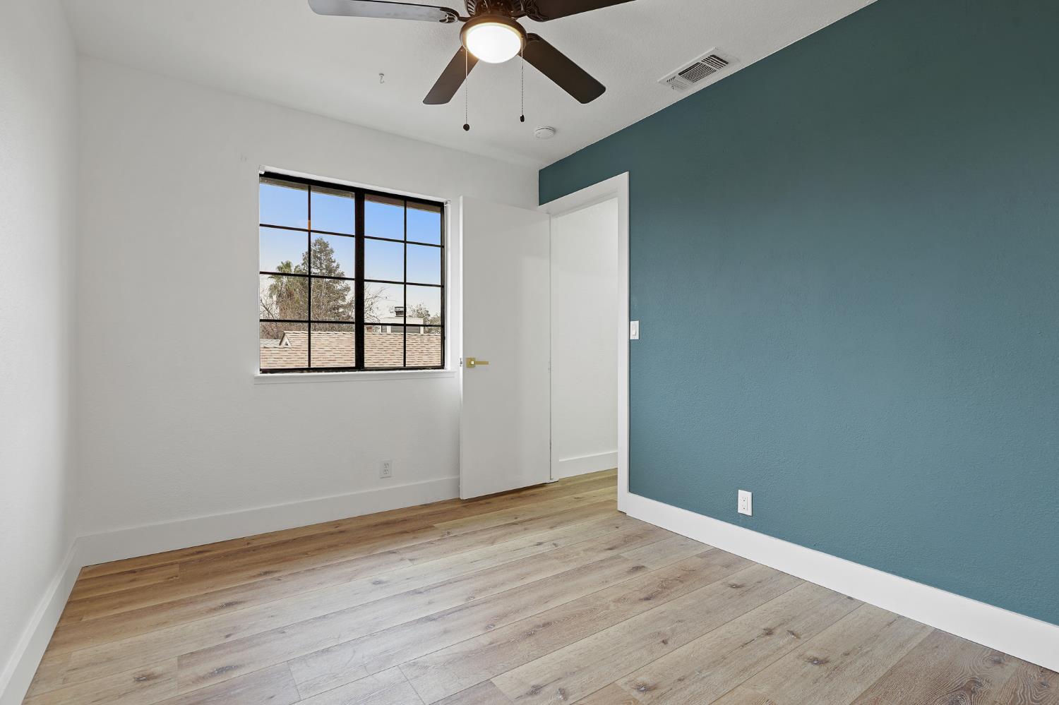 335 West Clover Road Tracy, CA 95376 - Photo 34 of 49 an empty room with wooden floor chandelier fan and windows
