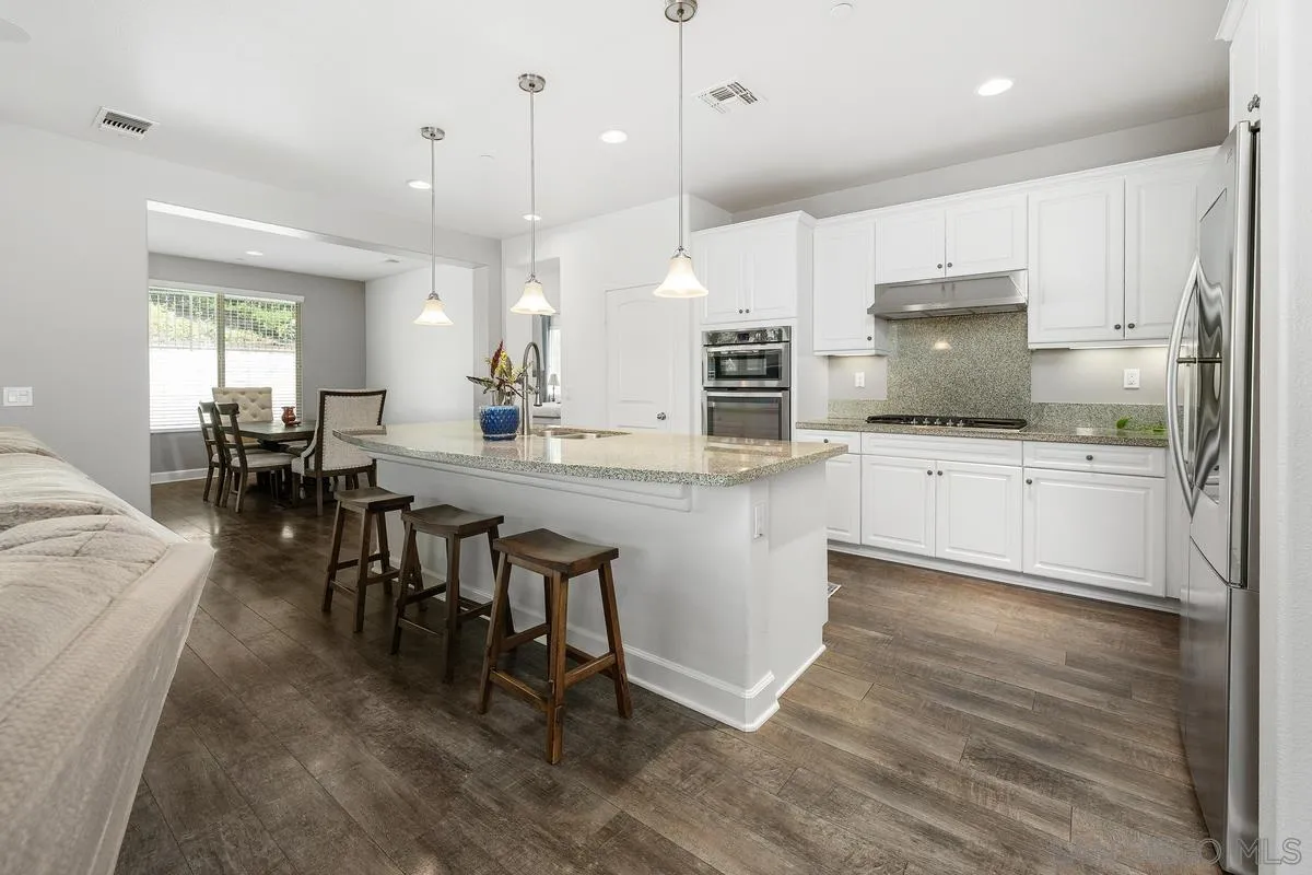 529 Adobe Estates Drive Vista, CA 92083 - Photo 5 of 39 a kitchen with kitchen island granite countertop a sink a counter top space stainless steel appliances and cabinets