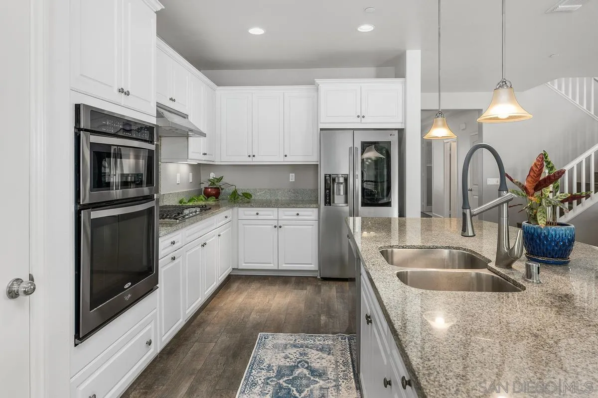 529 Adobe Estates Drive Vista, CA 92083 - Photo 6 of 39 a kitchen with granite countertop a sink stainless steel appliances and cabinets