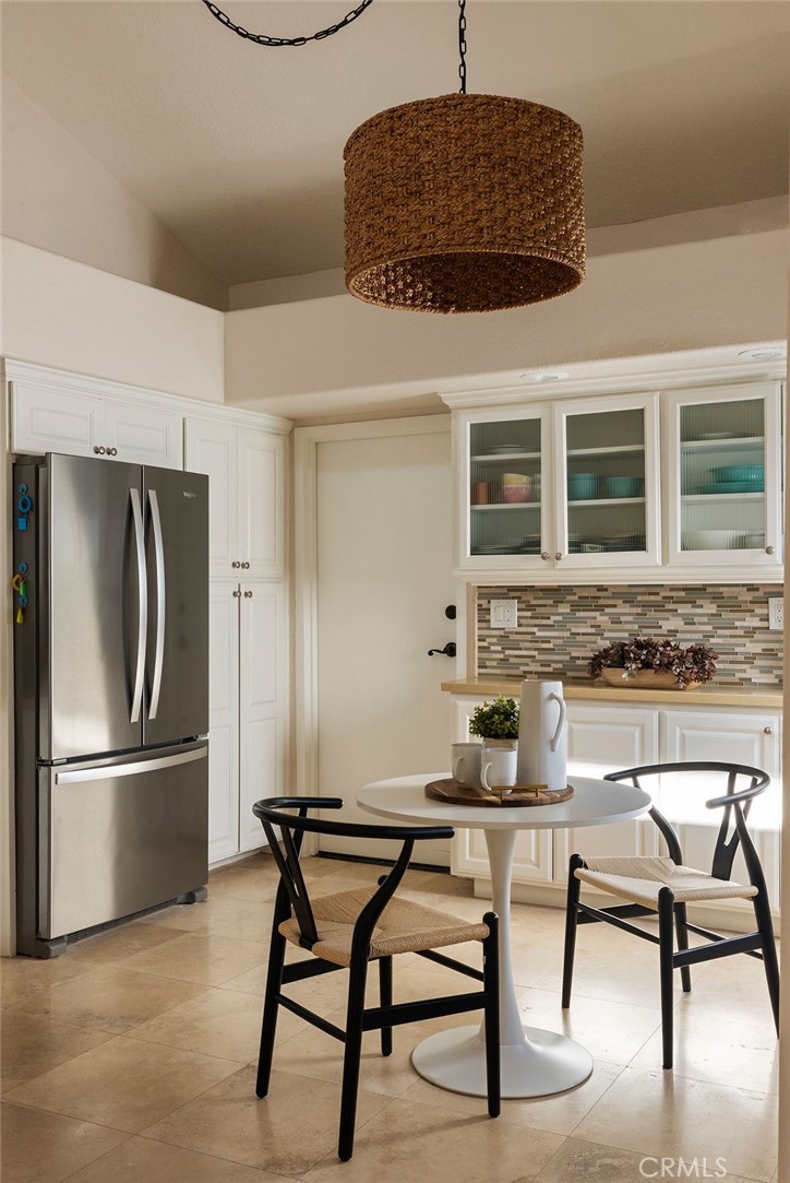 23274 Atlantis Way Dana Point, CA 92629 - Photo 13 of 53 a kitchen with granite countertop a table chairs stove and refrigerator