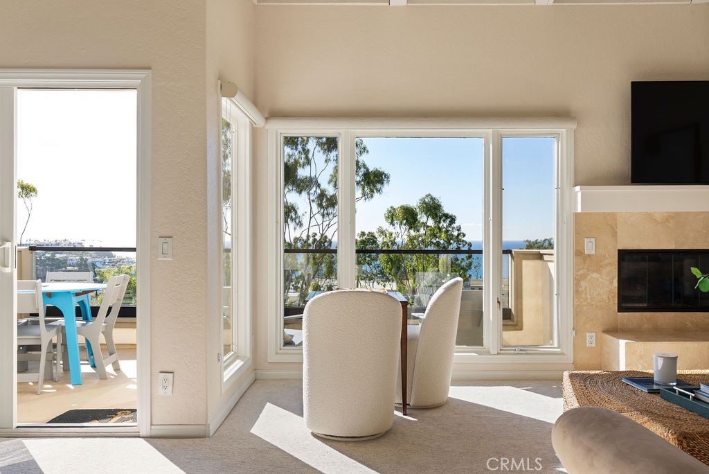 23274 Atlantis Way Dana Point, CA 92629 - Photo 26 of 53 a living room with a fireplace and a flat screen tv