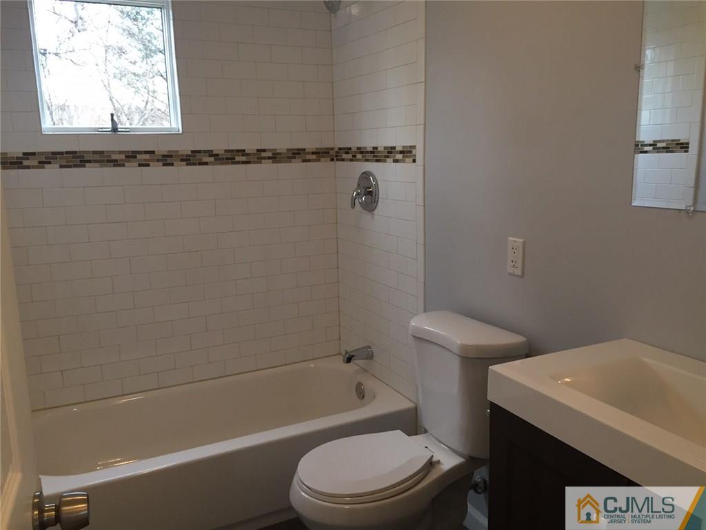 24 Sine Road Edison, NJ 08817 - Photo 7 of 11 a white toilet and tub sitting next to a window