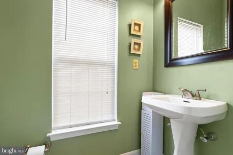 a bathroom with a sink a mirror and a window