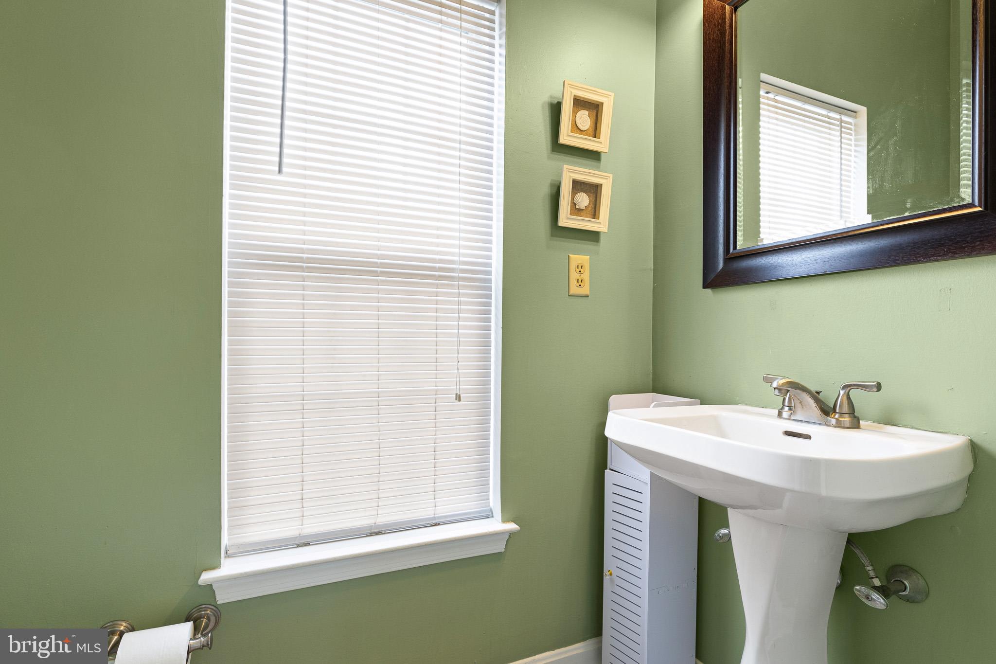 16 Highland Circle Newark, DE 19713 - Photo 11 of 20 a bathroom with a sink a mirror and a window