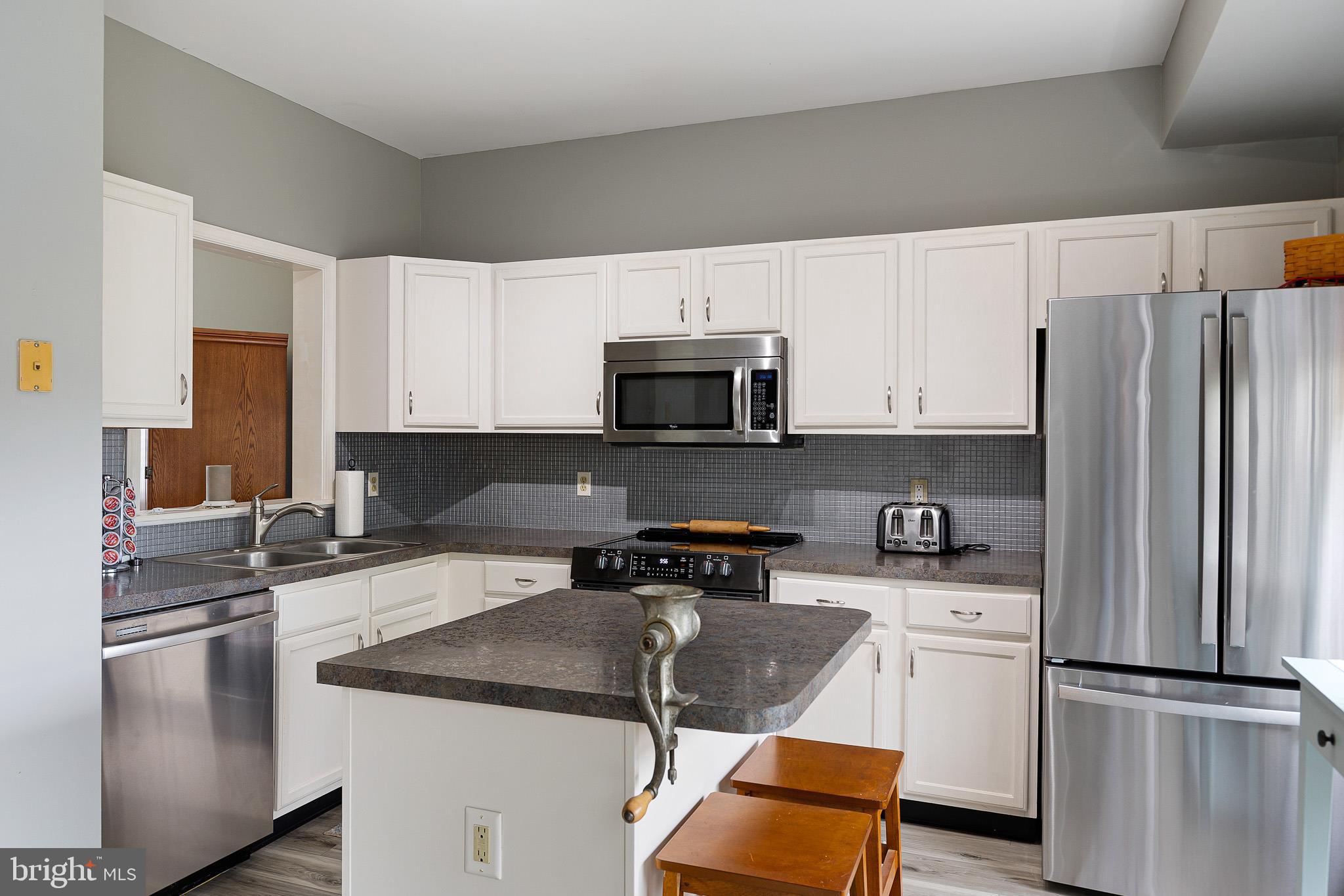 16 Highland Circle Newark, DE 19713 - Photo 3 of 20 a kitchen with a sink a microwave a refrigerator and cabinets