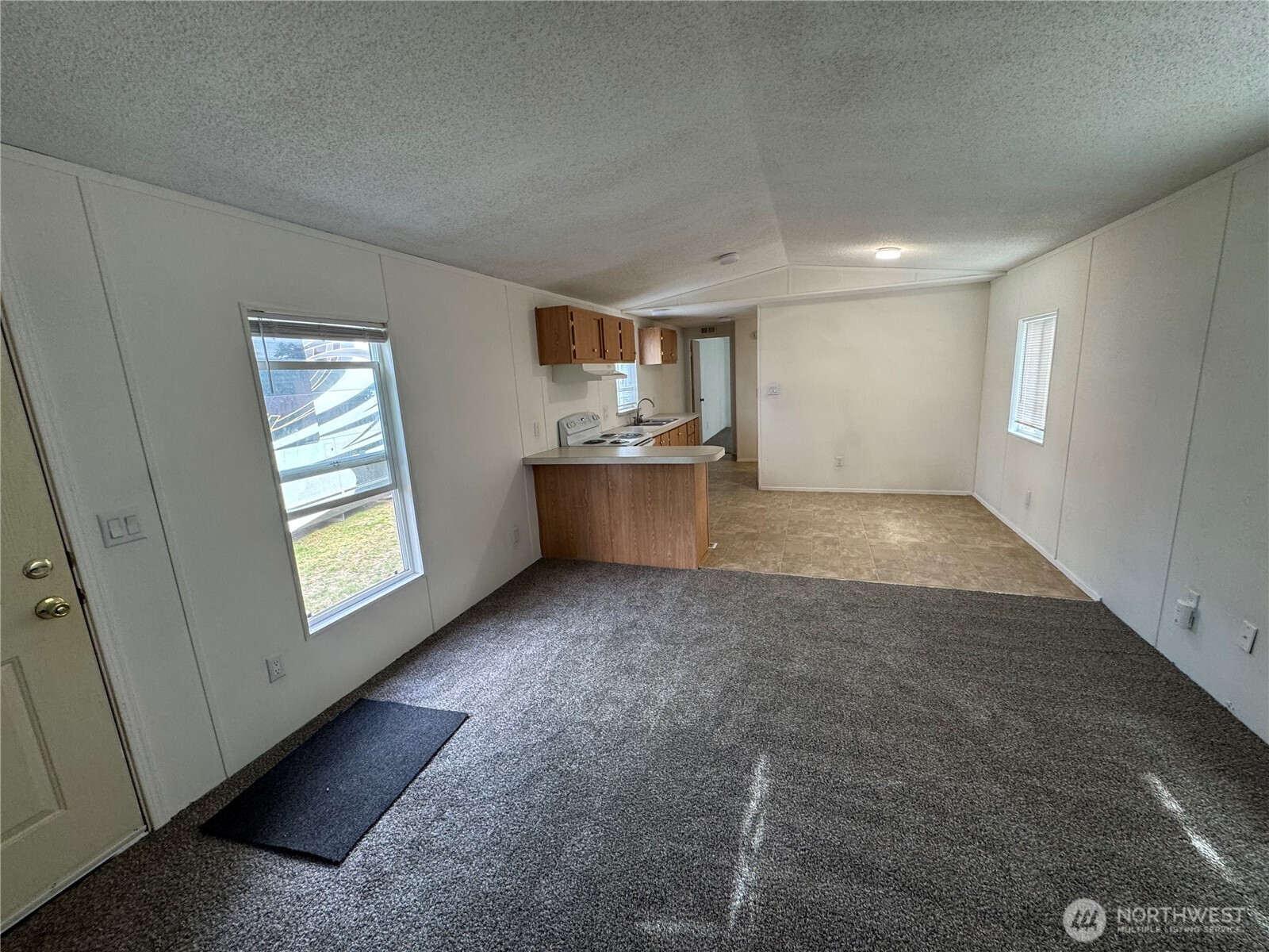 an empty room with windows and cabinet