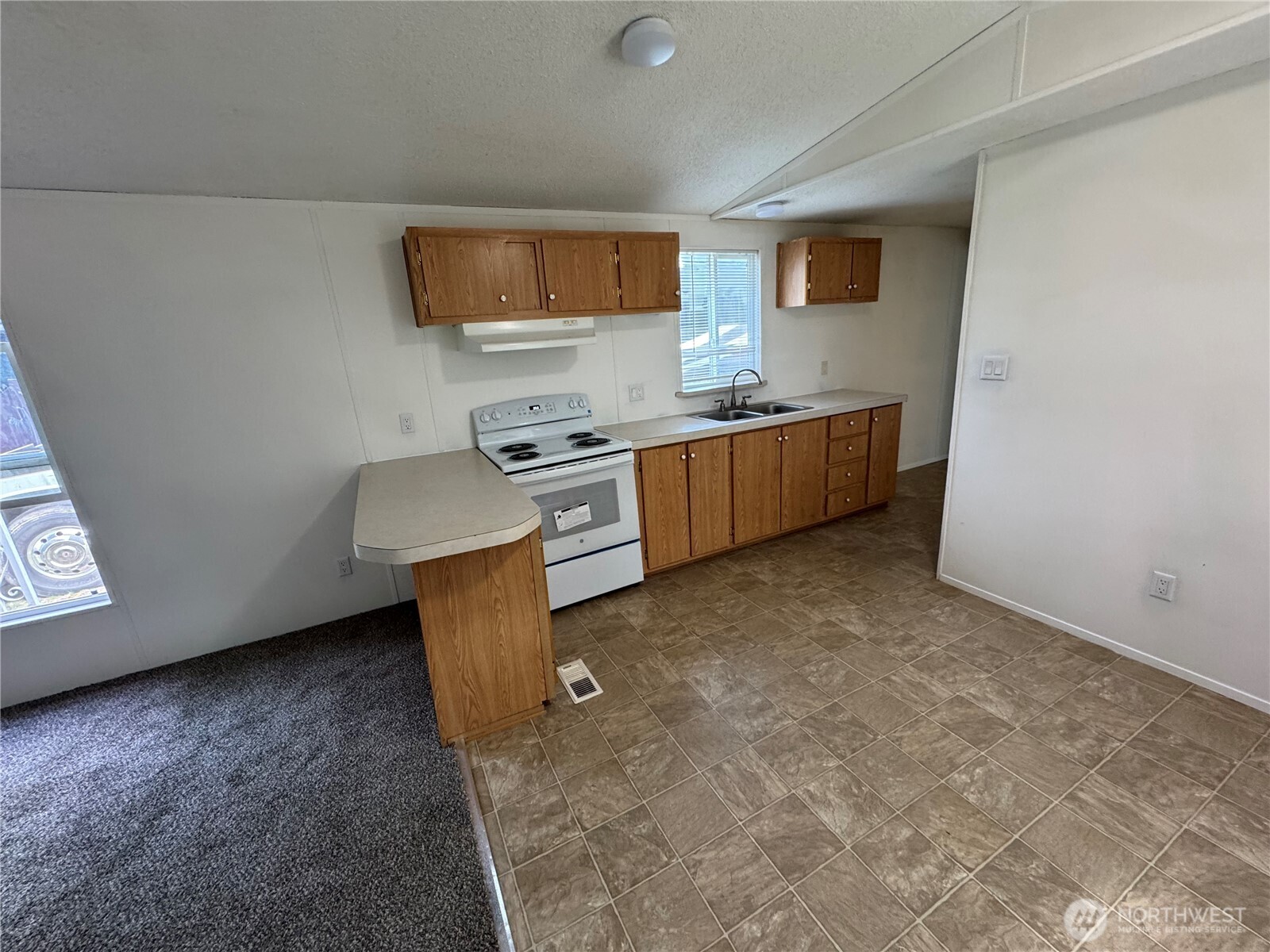 5705 Littlerock Road Southwest, Unit 30 Tumwater, WA 98512 - Photo 2 of 6 a kitchen with stainless steel appliances a stove a sink a microwave a counter top space and cabinets