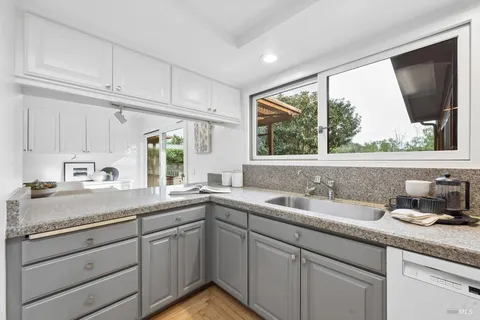 a kitchen with a sink cabinets and window