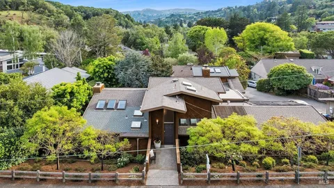 an aerial view of a house with yard swimming pool and mountain view in back