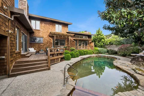 a front view of a house with swimming pool having outdoor seating