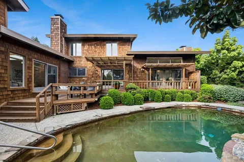 a view of a house with swimming pool and sitting area