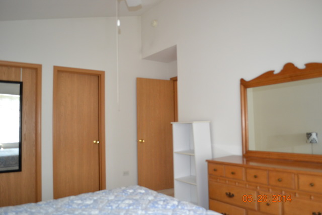 1446 McClure Road, Unit 1446 Aurora, IL 60505 - Photo 8 of 9 a bedroom with windows and cabinet