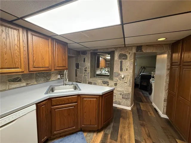 a kitchen with a sink a counter top space stainless steel appliances and cabinets
