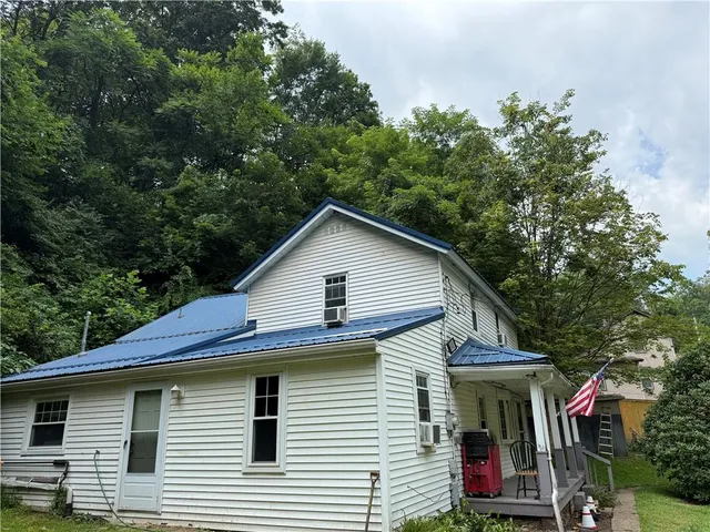 a view of a house with a yard and potted plants