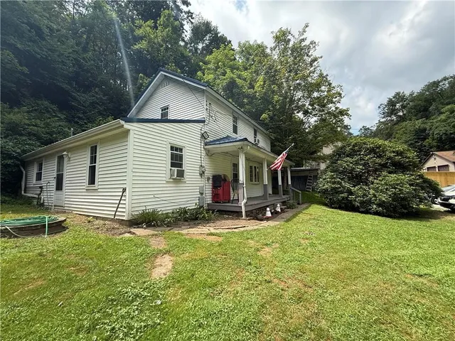a view of a house with a yard and sitting area