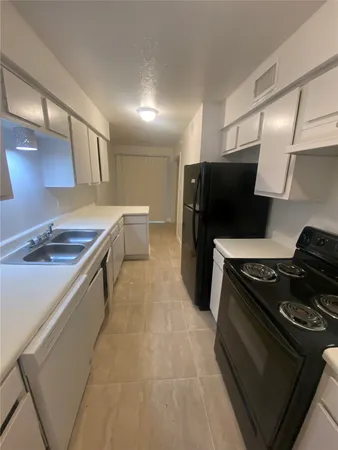 a kitchen with refrigerator and white counter top
