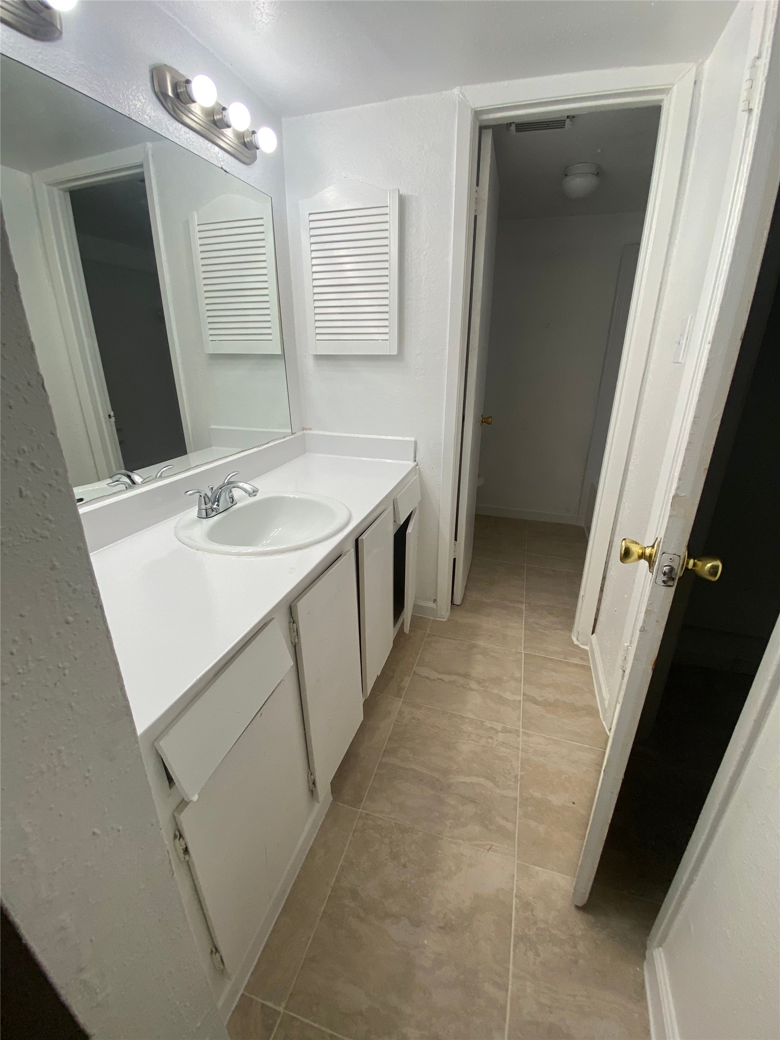 6200 West Tidwell Road, Unit 705 Houston, TX 77092 - Photo 9 of 12 a bathroom with a sink a vanity and a mirror