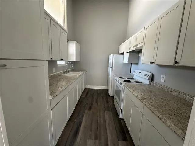 a kitchen with granite countertop sink stainless steel appliances and cabinets