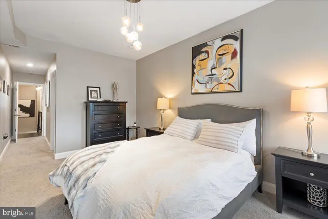 a bedroom with a bed and a lamp on dresser