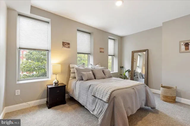 a bedroom with a bed and a large window