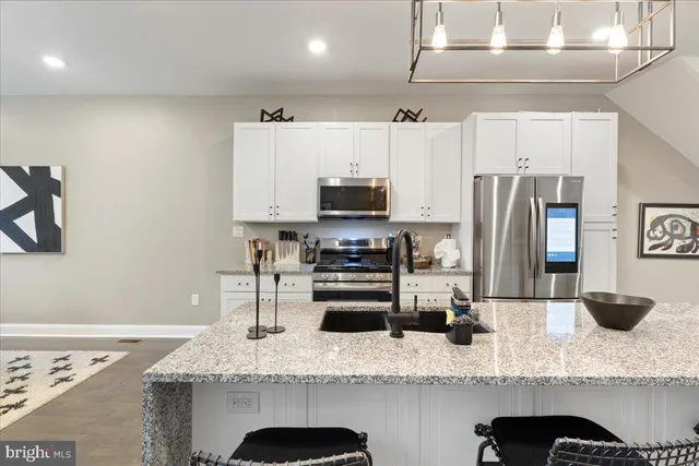 a kitchen with stainless steel appliances granite countertop a sink refrigerator and microwave