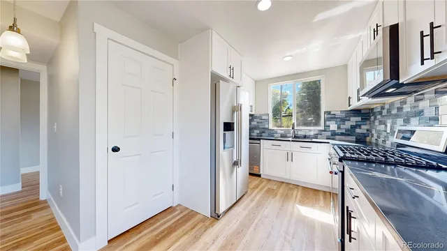 a kitchen with stainless steel appliances granite countertop a stove a sink and a microwave