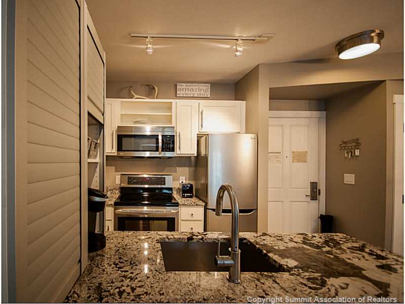 195 River Run Road, Unit 8054 Keystone, CO 80435 - Photo 6 of 24 a kitchen with a refrigerator and a stove top oven