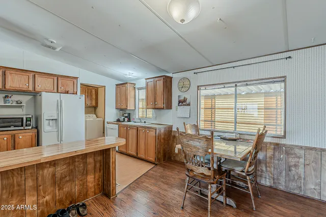 a kitchen with stainless steel appliances a table chairs refrigerator and microwave