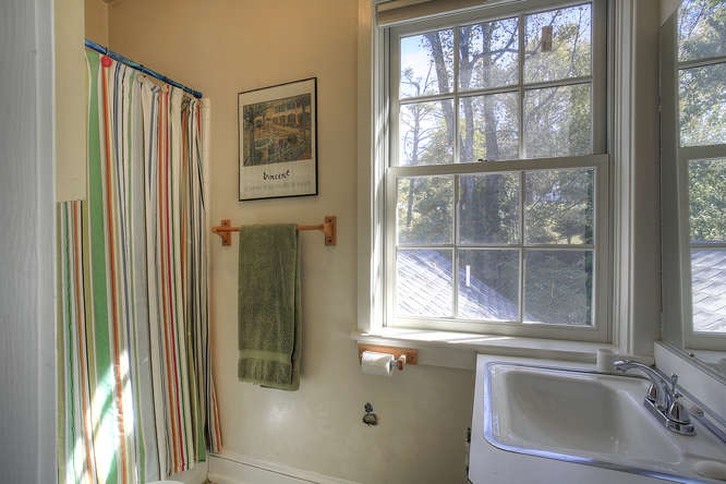 1454 Rugby Road Charlottesville, VA 22903 - Photo 17 of 33 a bathroom with a sink a mirror and next to a window