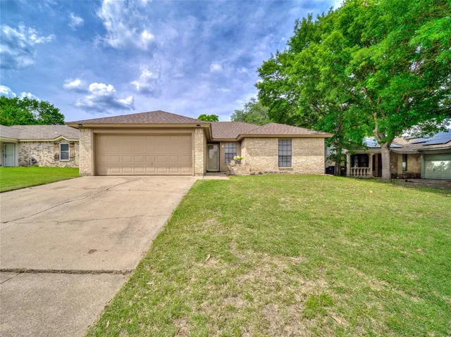 a front view of a house with a yard and trees