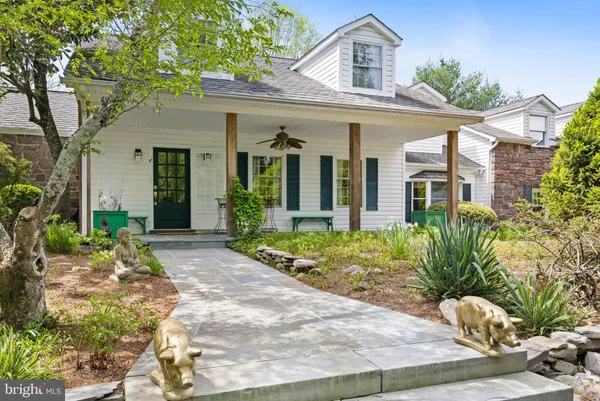 a front view of a house with garden and trees
