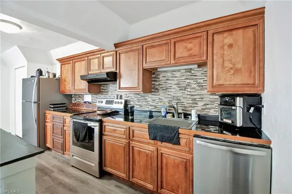 a kitchen with stainless steel appliances granite countertop a stove sink microwave and refrigerator