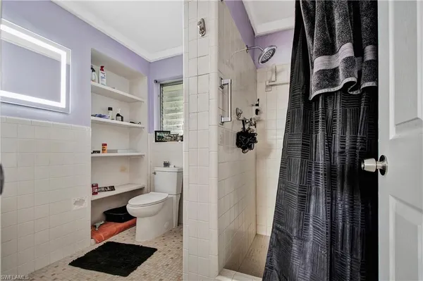 a bathroom with a toilet and a shower