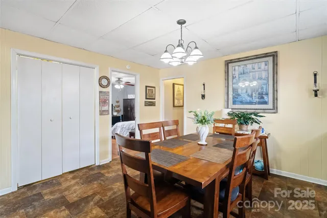 a view of a dining room with furniture a chandelier and wooden floor