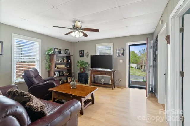 a living room with furniture a flat screen tv and a large window
