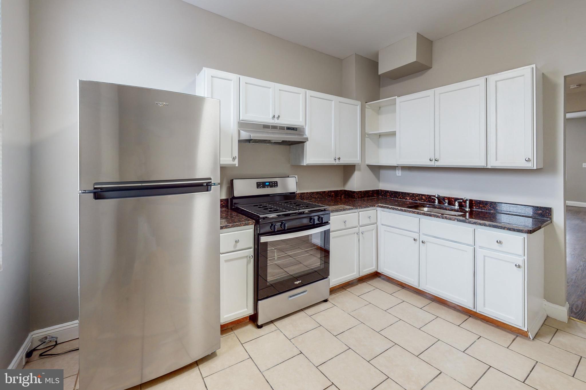 a kitchen with white cabinets and white appliances