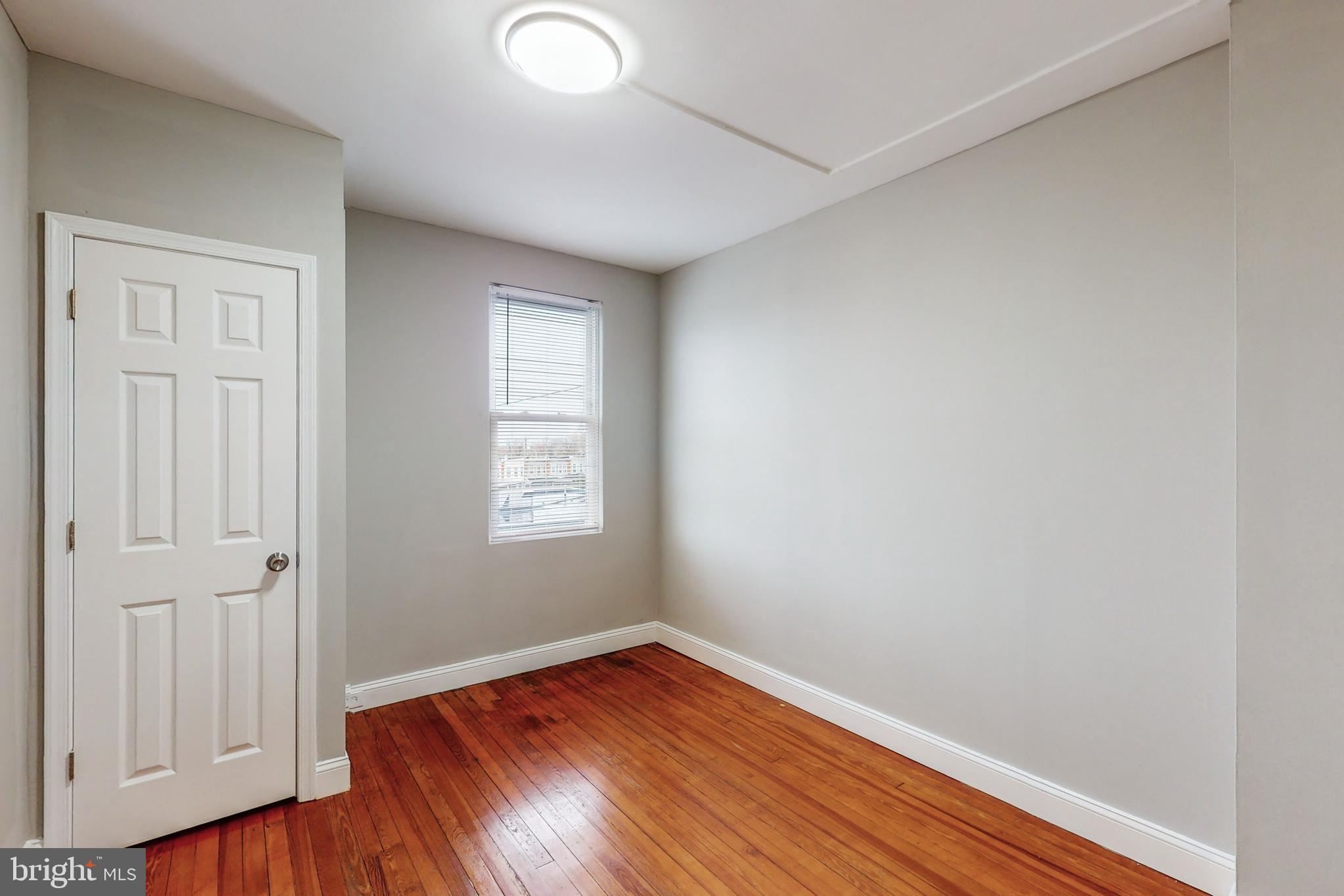 2867 Mayfield Avenue Baltimore, MD 21213 - Photo 11 of 25 an empty room with wooden floor and windows