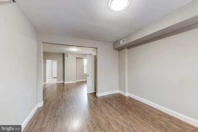 a view of empty room with wooden floor