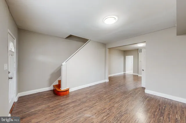 a view of an empty room with wooden floor