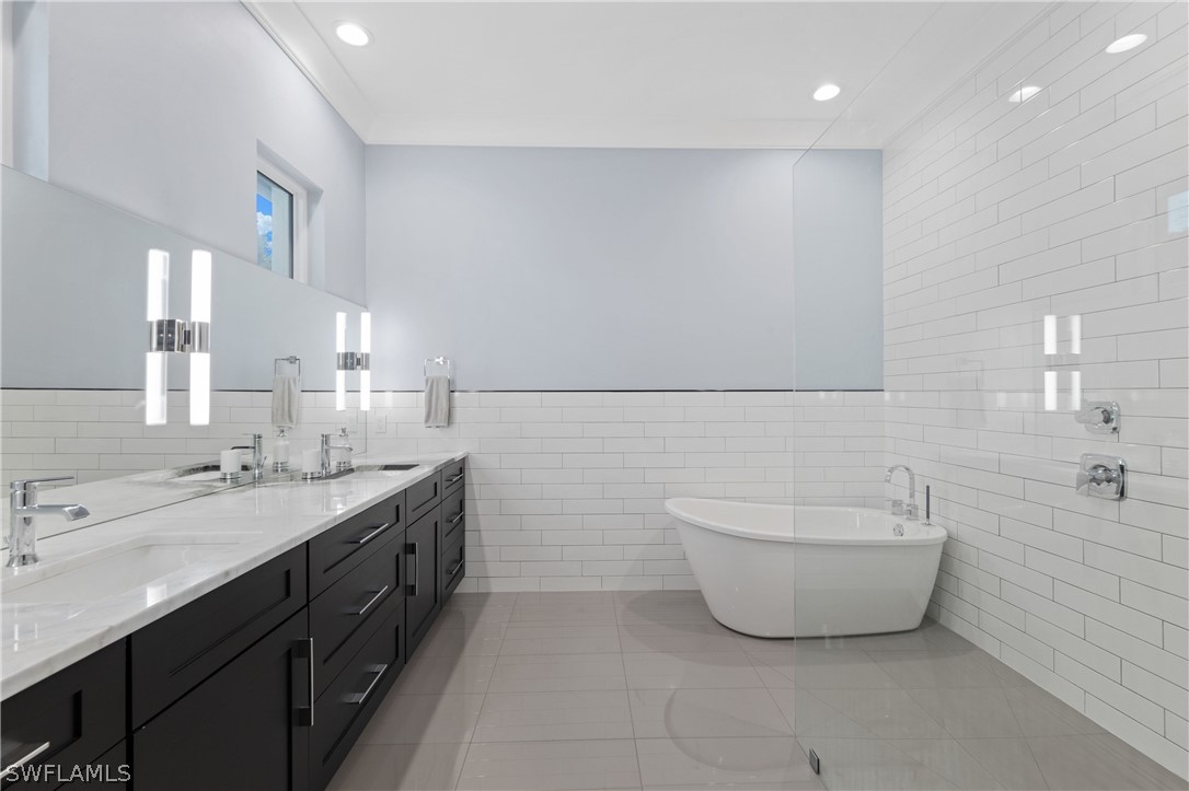 1606 Ardmore Road Fort Myers, FL 33901 - Photo 21 of 33 a spacious bathroom with a double vanity sink a mirror and a bathtub