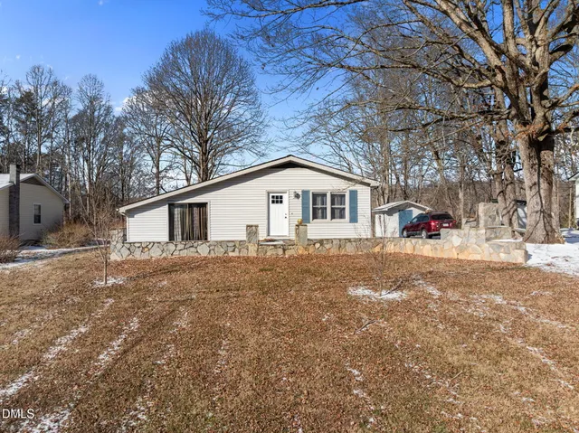 a white house covered with tall trees