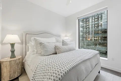 a bedroom with a large bed and a lamp next to a window