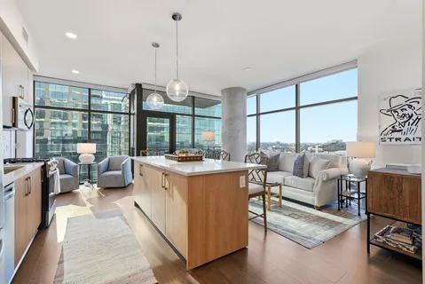 a open kitchen with stainless steel appliances granite countertop a stove top oven a dining table and chairs with outer view