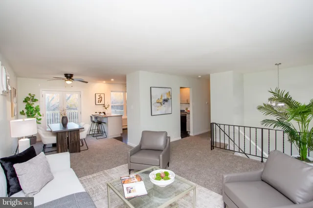 a living room with lots of furniture and kitchen view