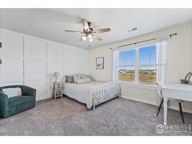 a spacious bedroom with a bed a table and chair